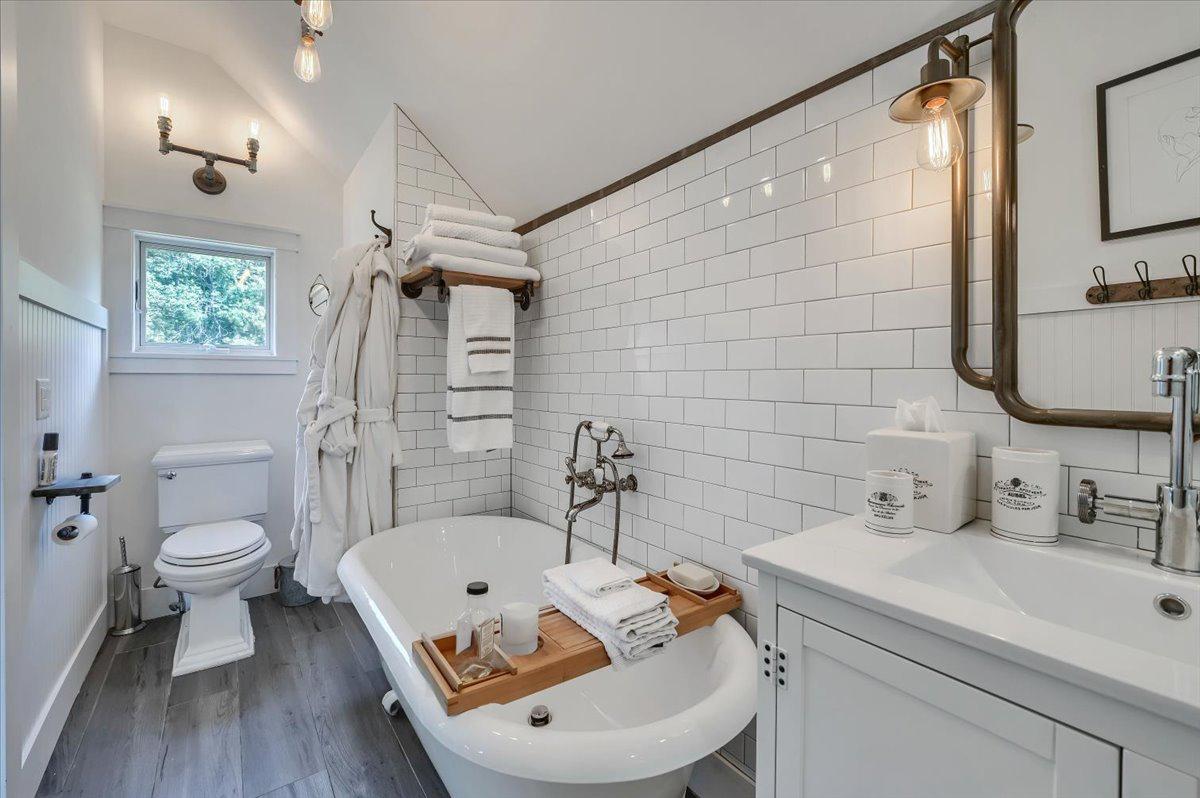 En-suite bathroom at The Westtown Reset — clawfoot soaking tub, subway tile, brass fixtures