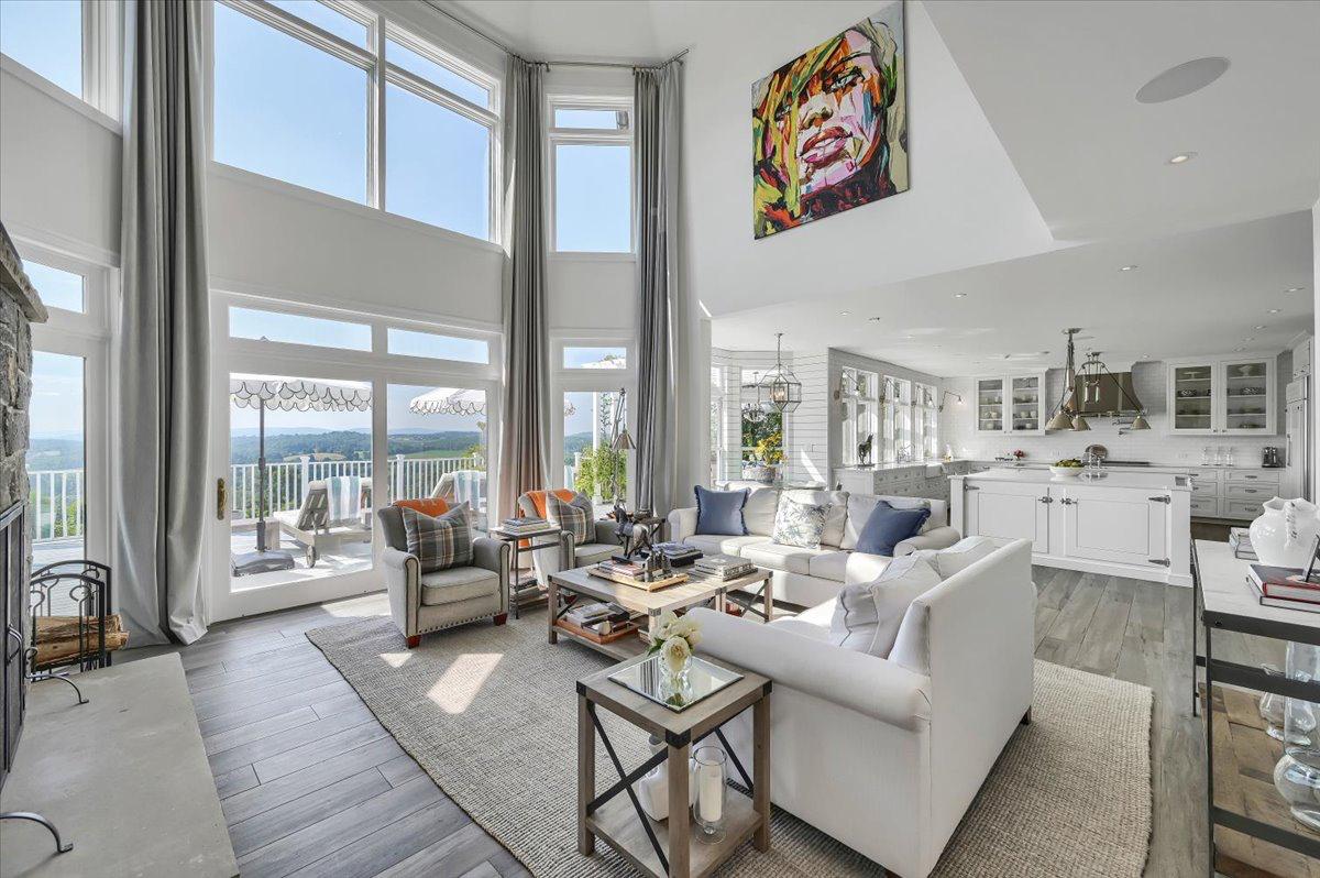 Open-plan living room at The Westtown Reset — floor-to-ceiling windows, fireplace, valley views