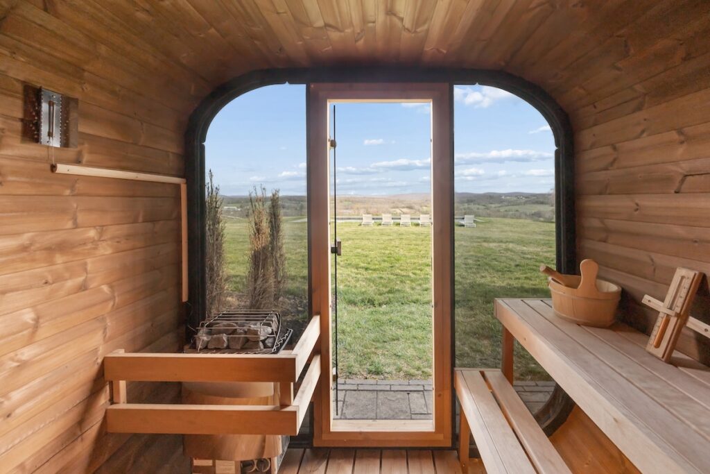 Cedar barrel sauna interior with glass door overlooking rolling hills at The Westtown Reset — private estate upstate NY